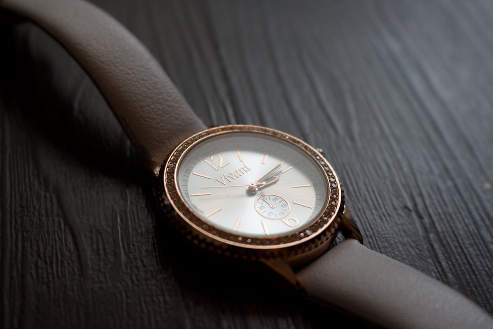 round gold-colored and white chronograph watch