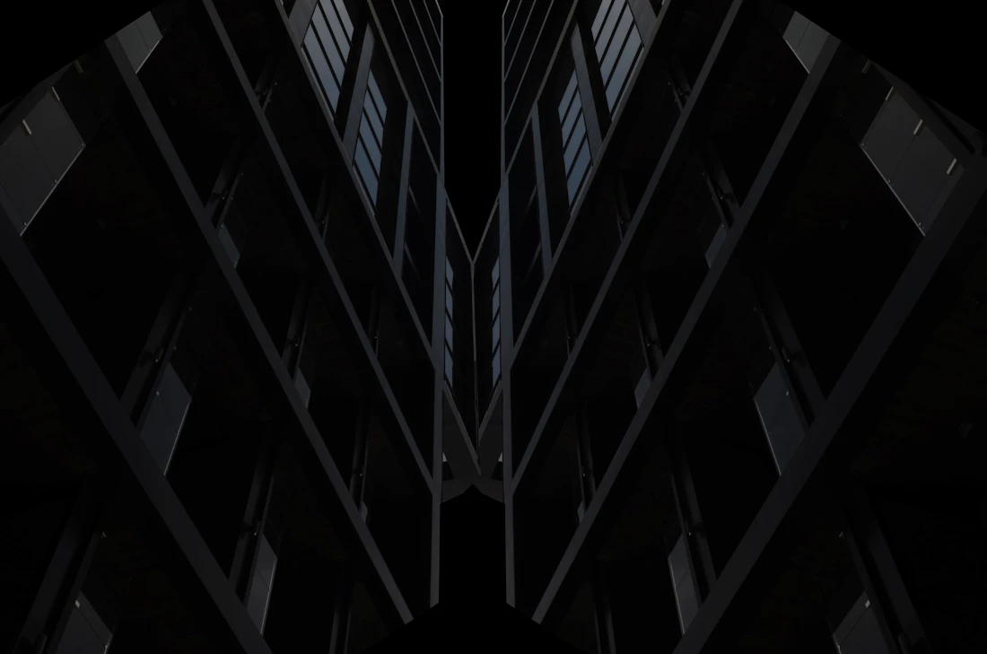Two modern towers at night viewed from below