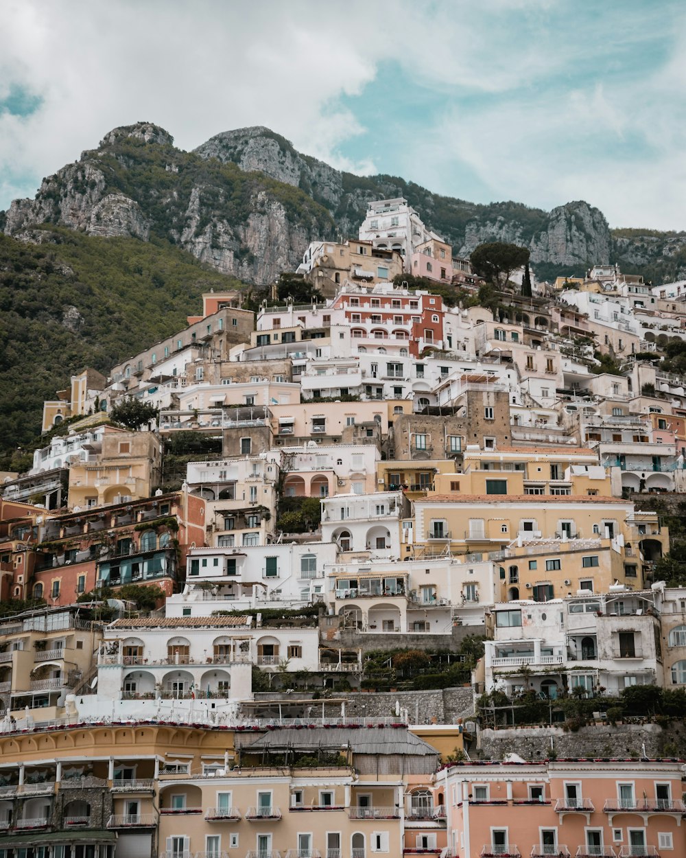 houses near mountain under cloudy sky during daytime