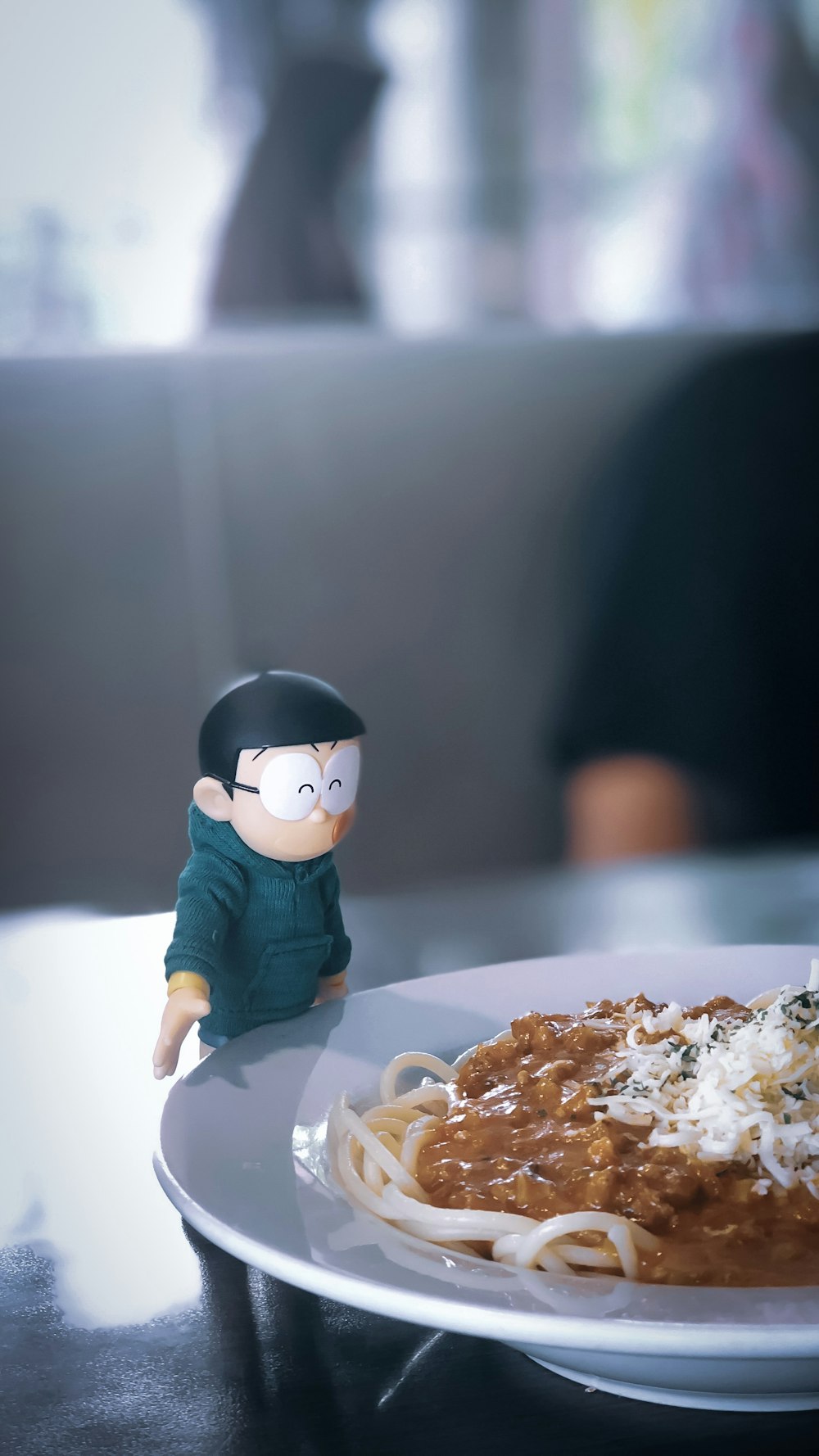 Nobita figurine beside plate of pasta