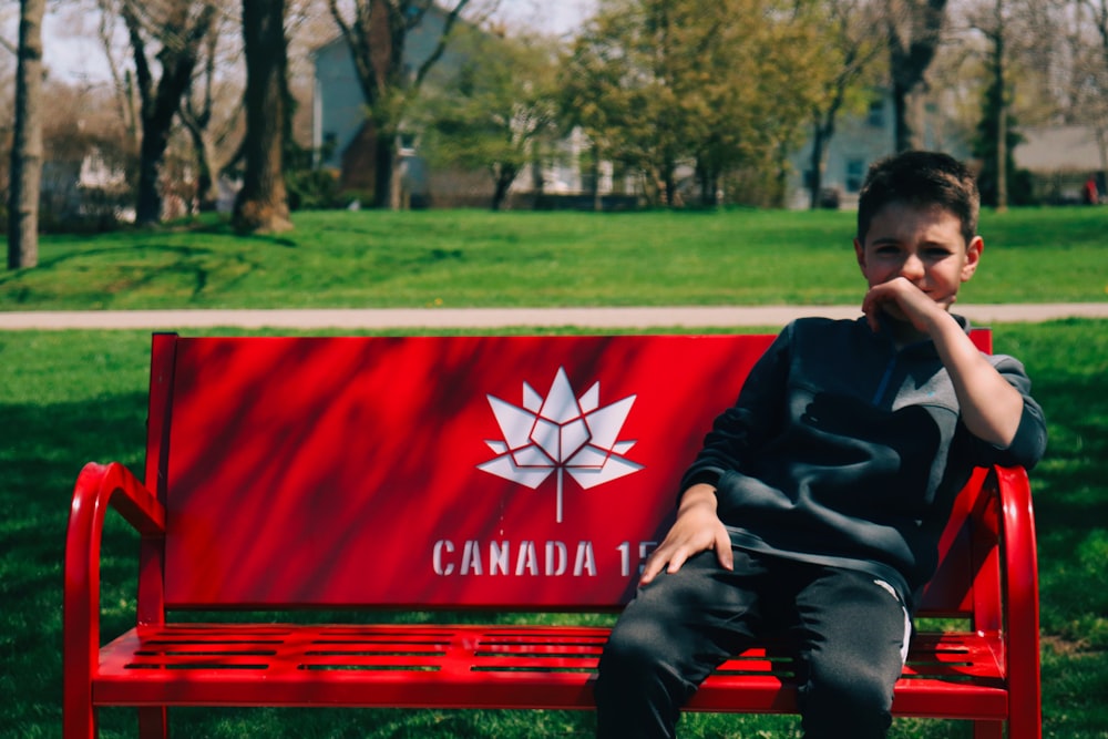 boy sitting on red chair