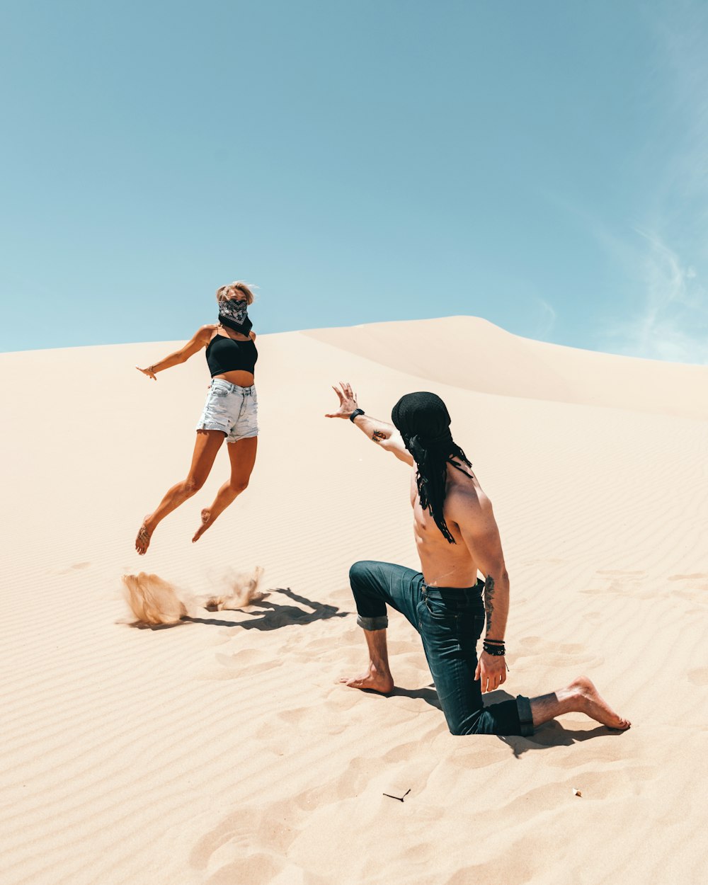 man wearing blue jeans across woman jumping