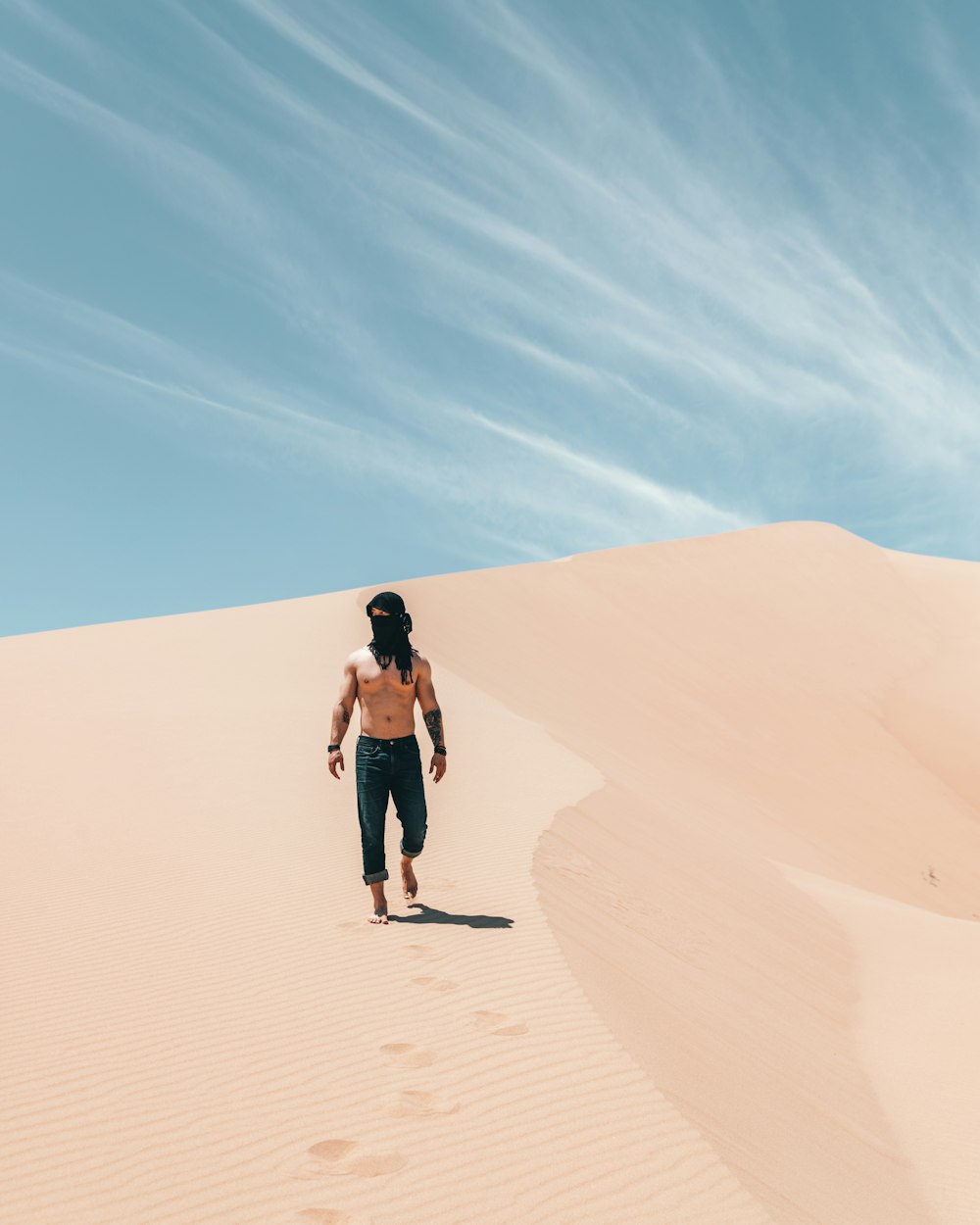 topless man standing on desert during daytime