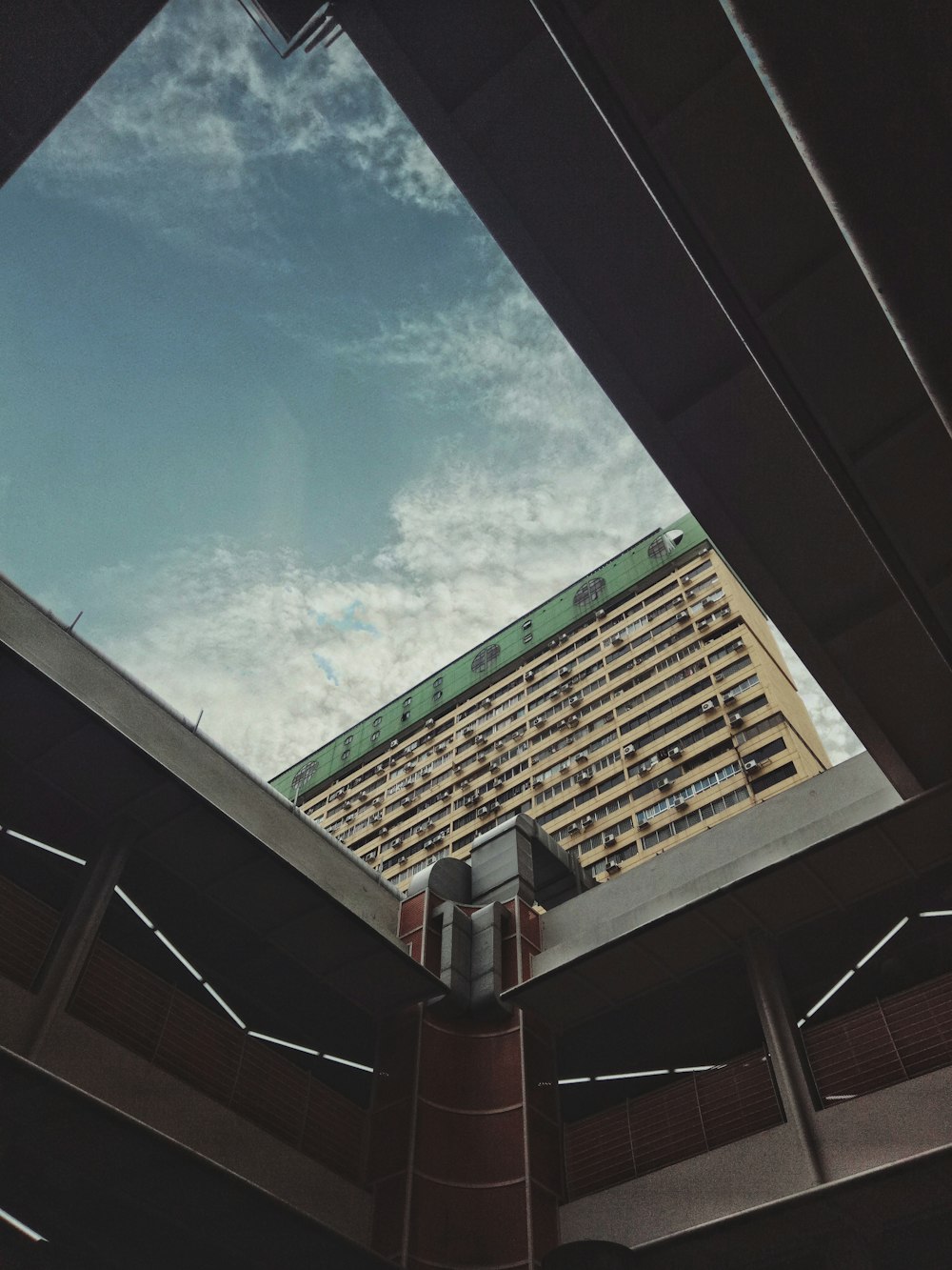 worm view photo of concrete building under cloudy sky during daytime