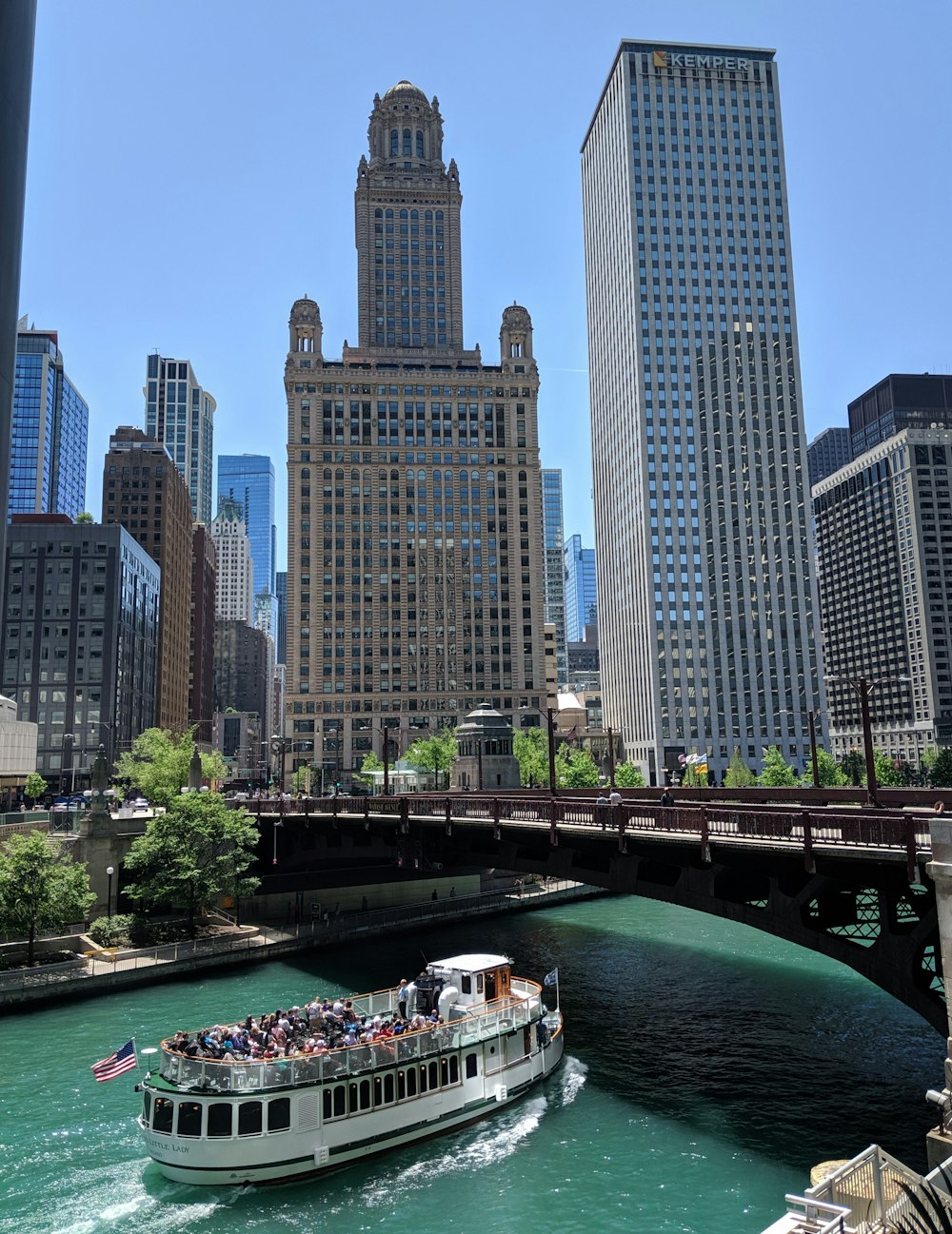 Bateau blanc avec des passagers traversant sous le pont pendant la journée