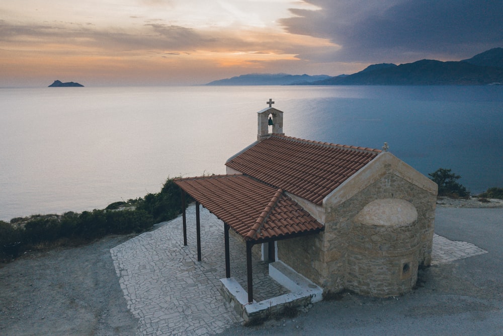 brown concrete chapel near body of water