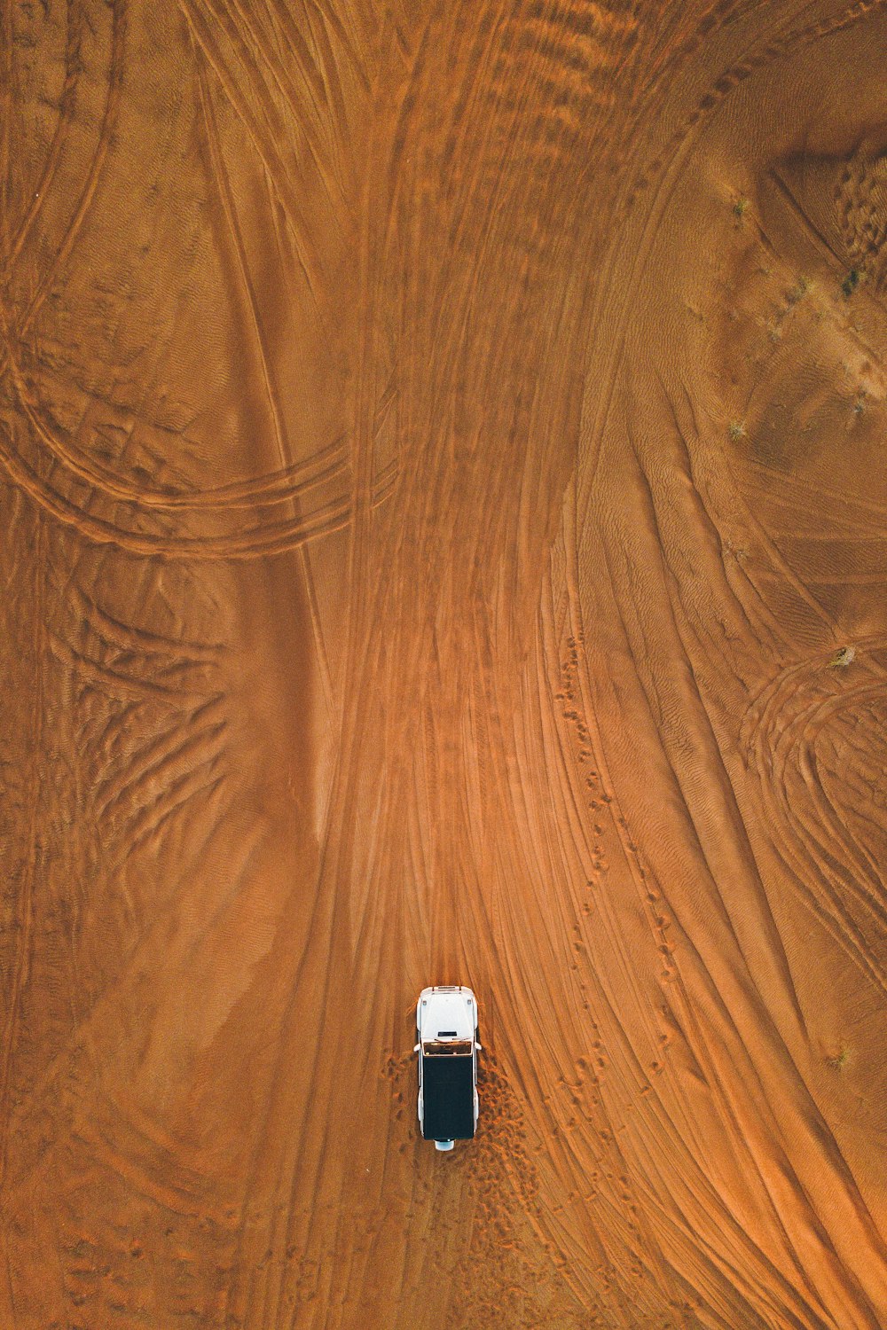 fotografia aerea di SUV bianco che naviga sulla sabbia