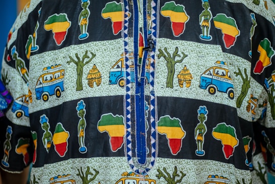 Close-up of traditional African textiles in rich terra-cotta reds and emerald greens, symbolizing heritage and unity.