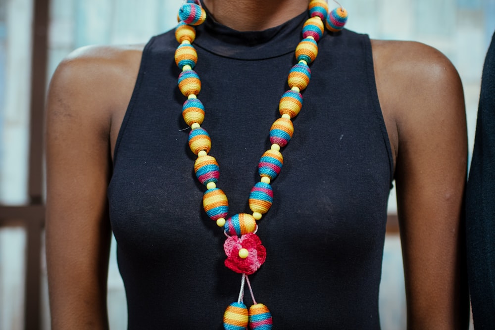 woman wearing black dress and black and yellow necklace