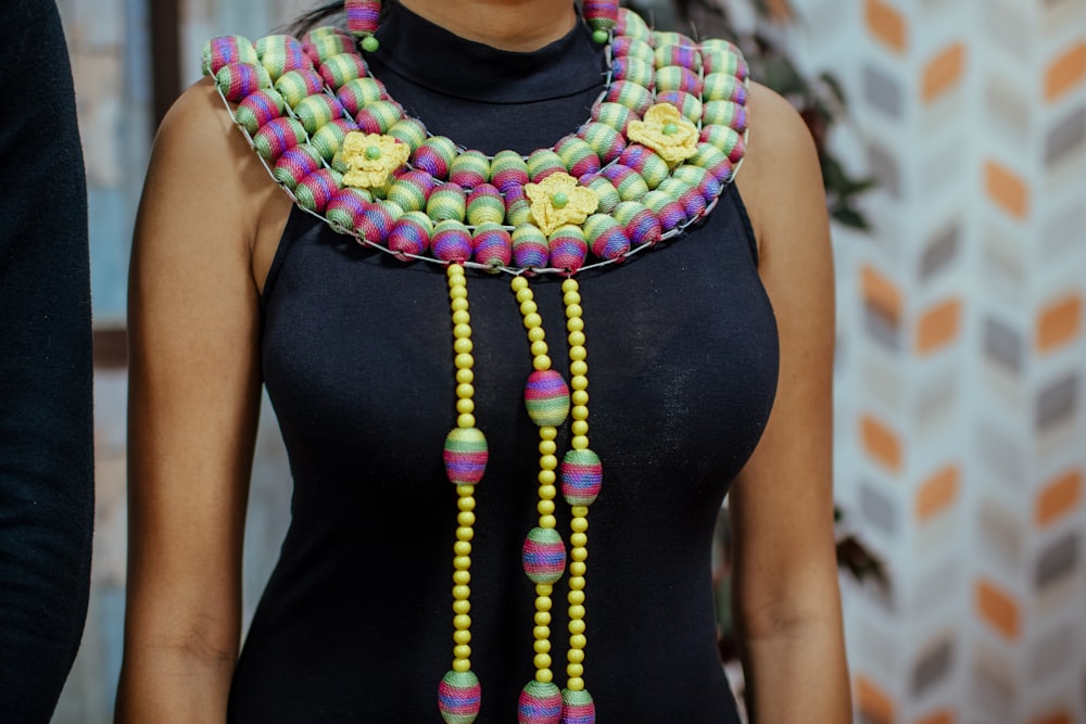 woman wearing beaded bib necklace and sleeveless top