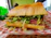 Close-up of a colorful deli sandwich stacked with fresh veggies and meats on artisan bread.