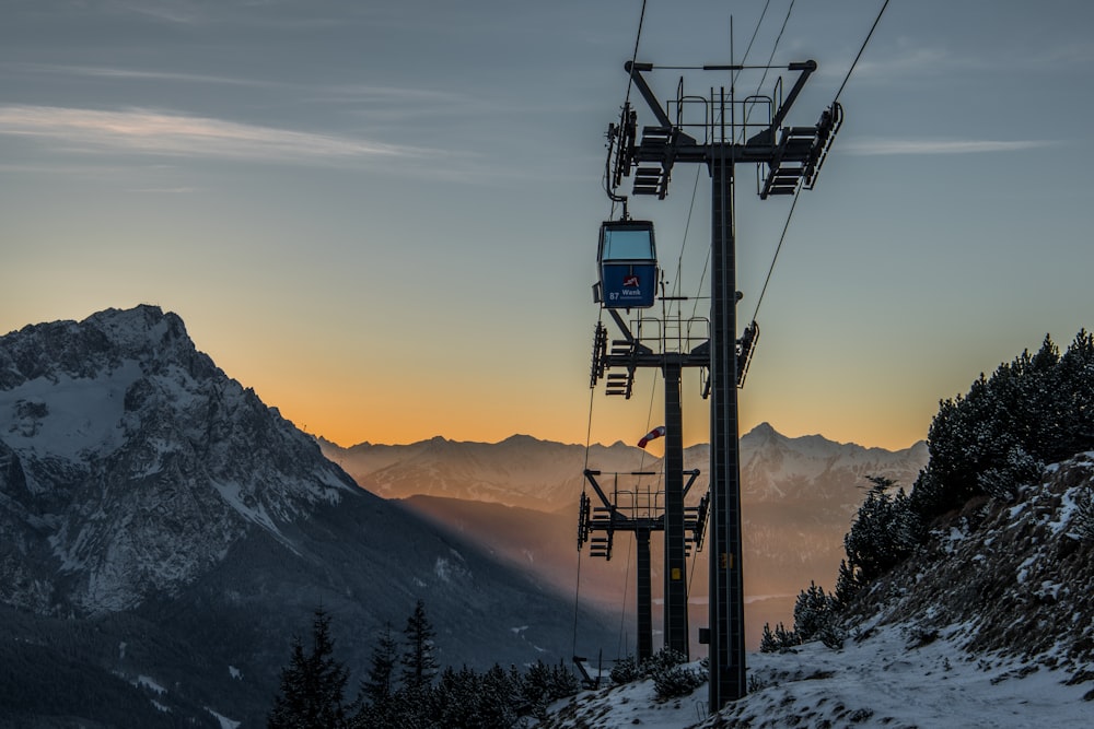 Carros de cable sobre la nieve y los campos y montañas cubiertos de árboles