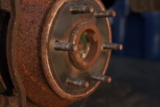 Shot of a rugged van wheel with tire and rusty brake parts, set against a charcoal black background.