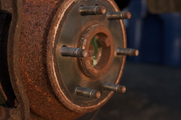 Shot of a rugged van wheel with tire and rusty brake parts, set against a charcoal black background.