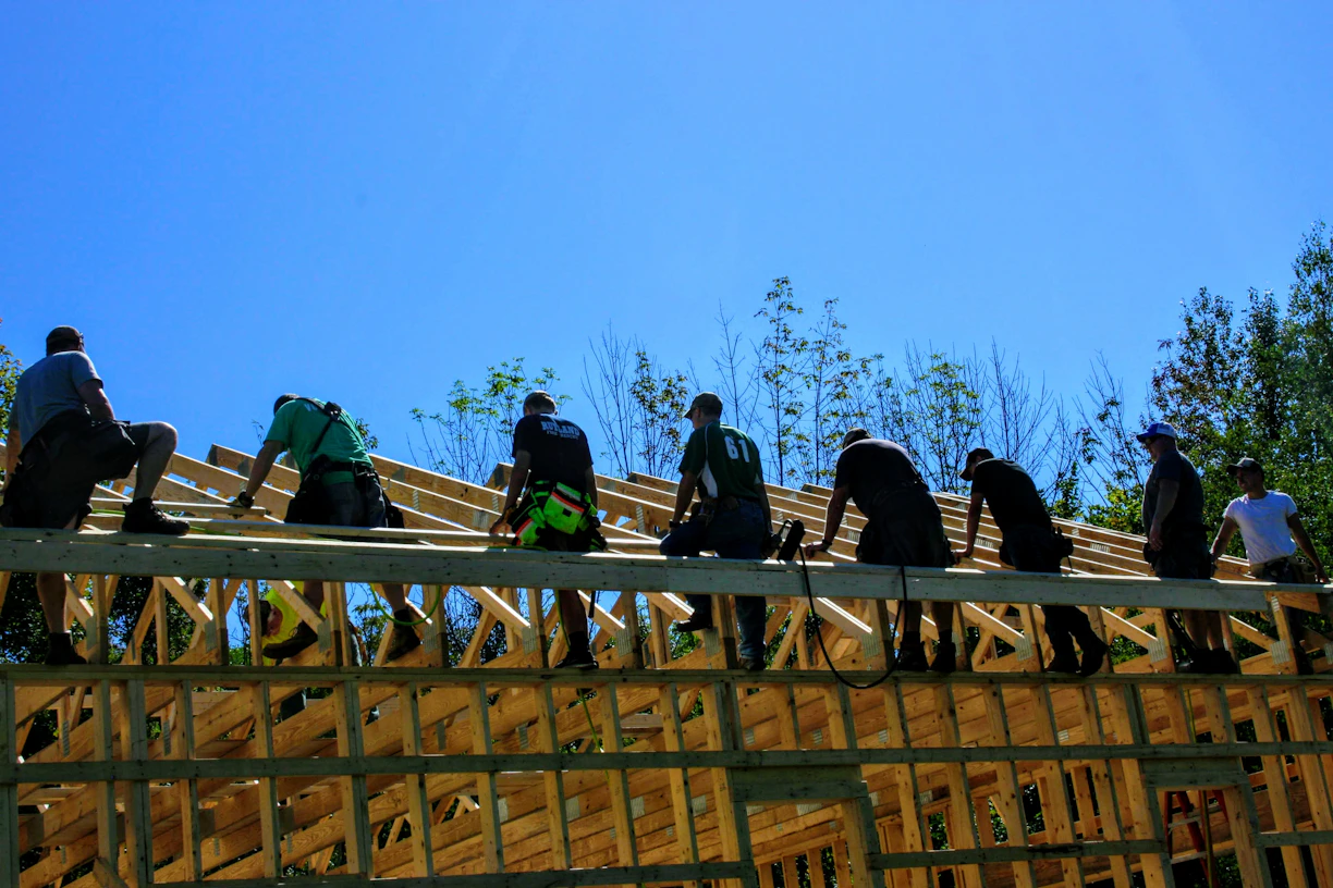 A skilled construction team collaborating on a building site under clear blue skies.