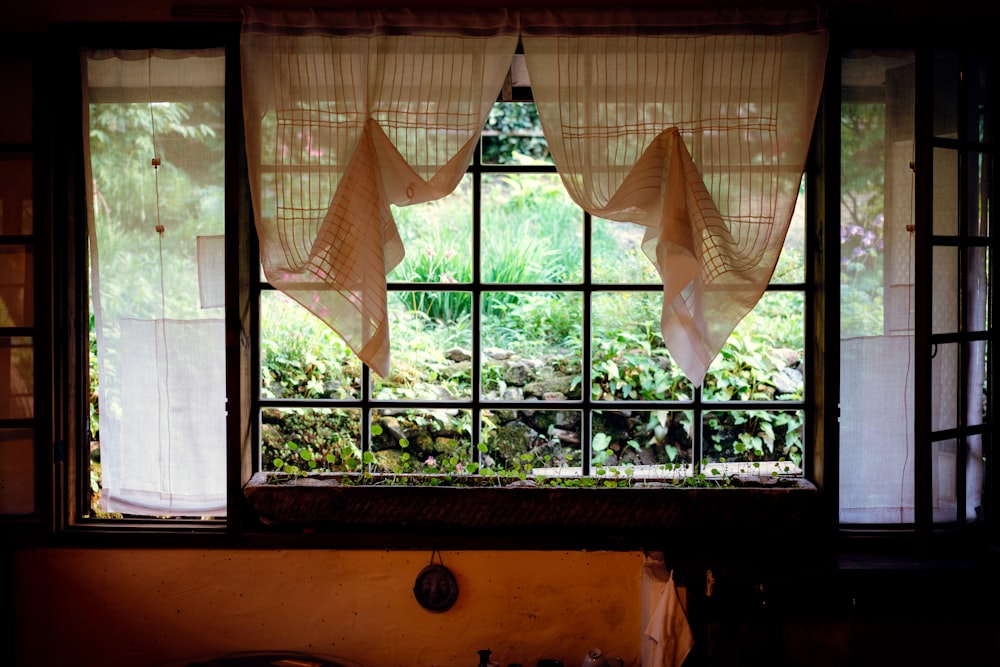 orange window curtains opened near brown wooden chair