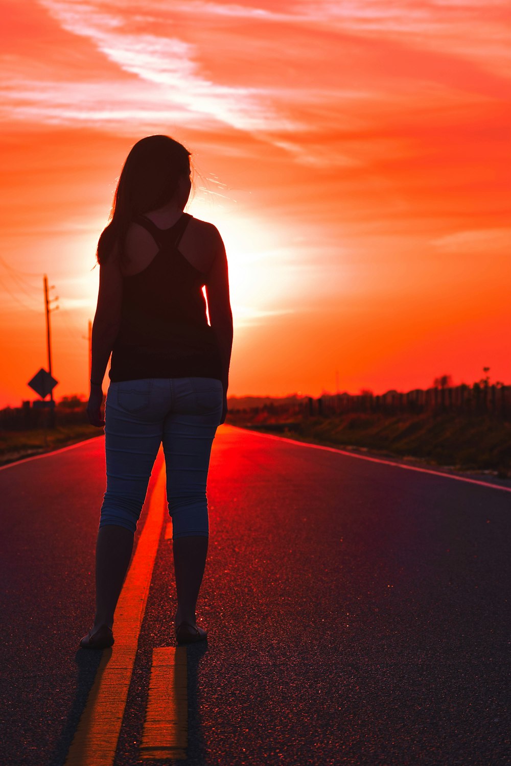 woman standing at road during sunset