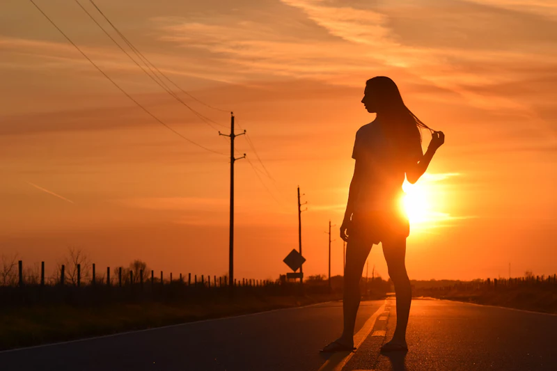Runner in silhouette on the road against the rising sun