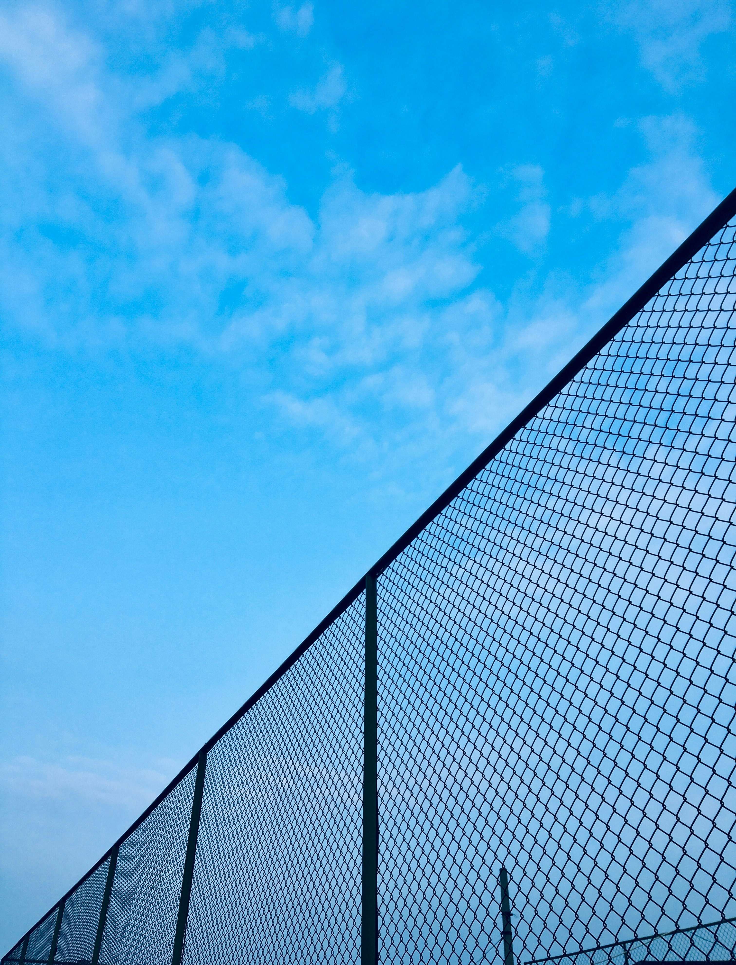chain-link fence under blue sky during daytime