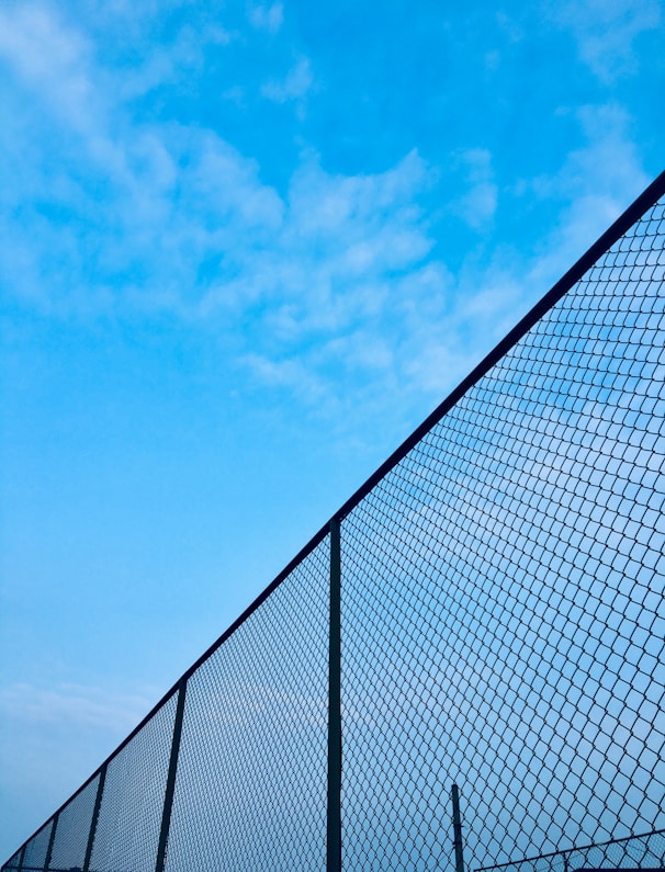 chain-link fence under blue sky during daytime