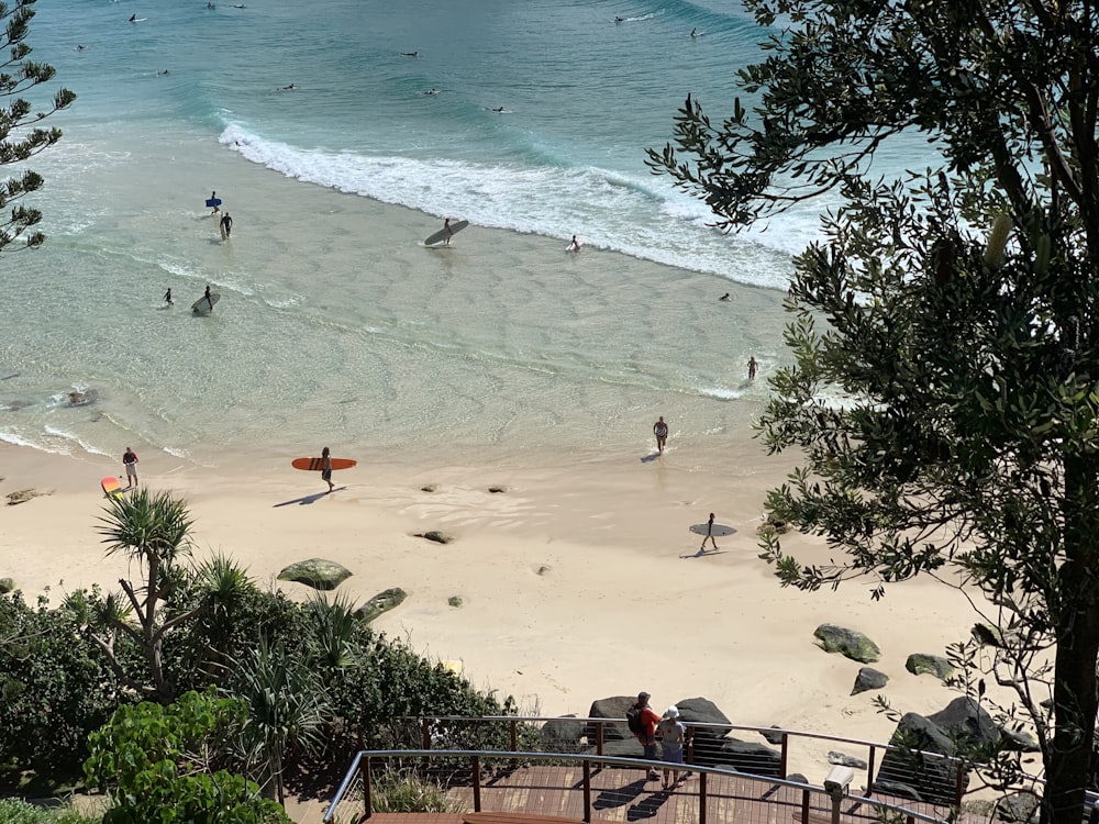 a group of people standing on top of a sandy beach