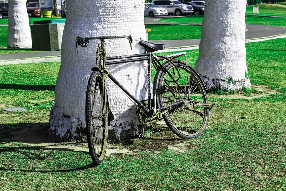 road bike parked beside tree near parked cars