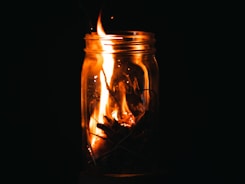 a fire in a glass jar with a black background
