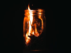 a fire in a glass jar with a black background