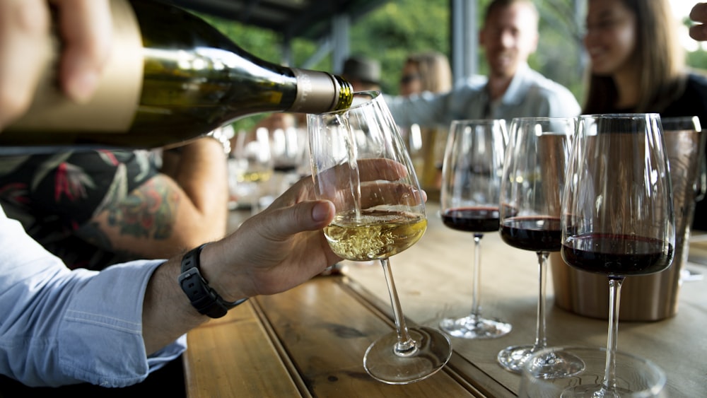 Un grupo de personas sentadas en una mesa con copas de vino