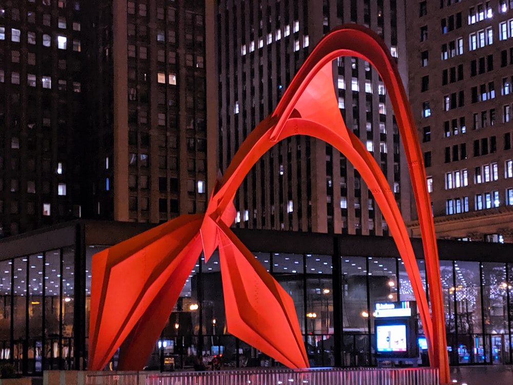 red abstract sculpture near building during night