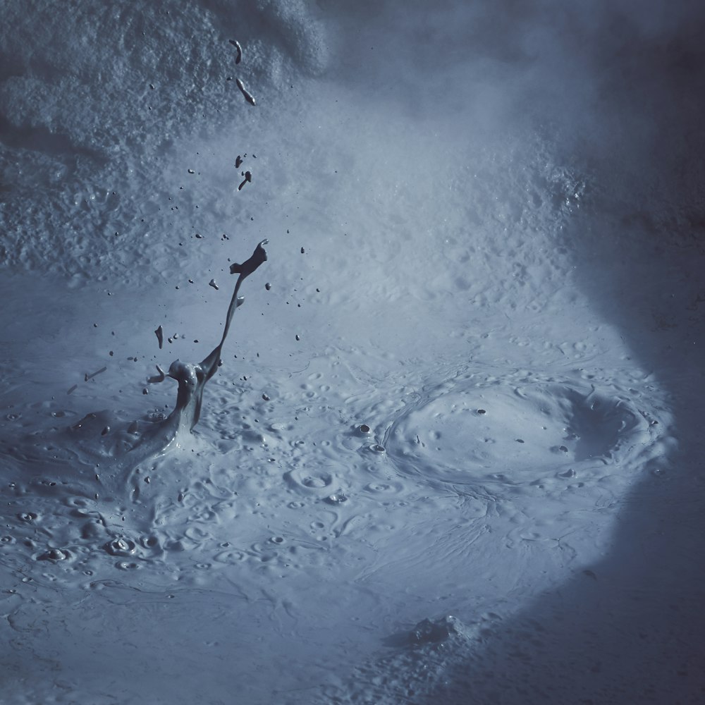 a large puddle of water in the middle of a snow covered ground