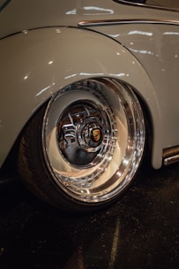 Close-up of a polished tire and rim shining beside a spotless door panel.