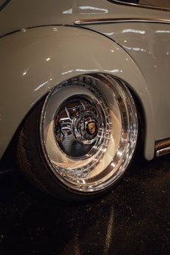 Detailer polishing chrome rims under bright garage lights.