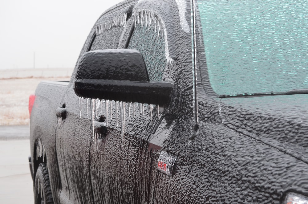 black pickup truck covered with iced water dew