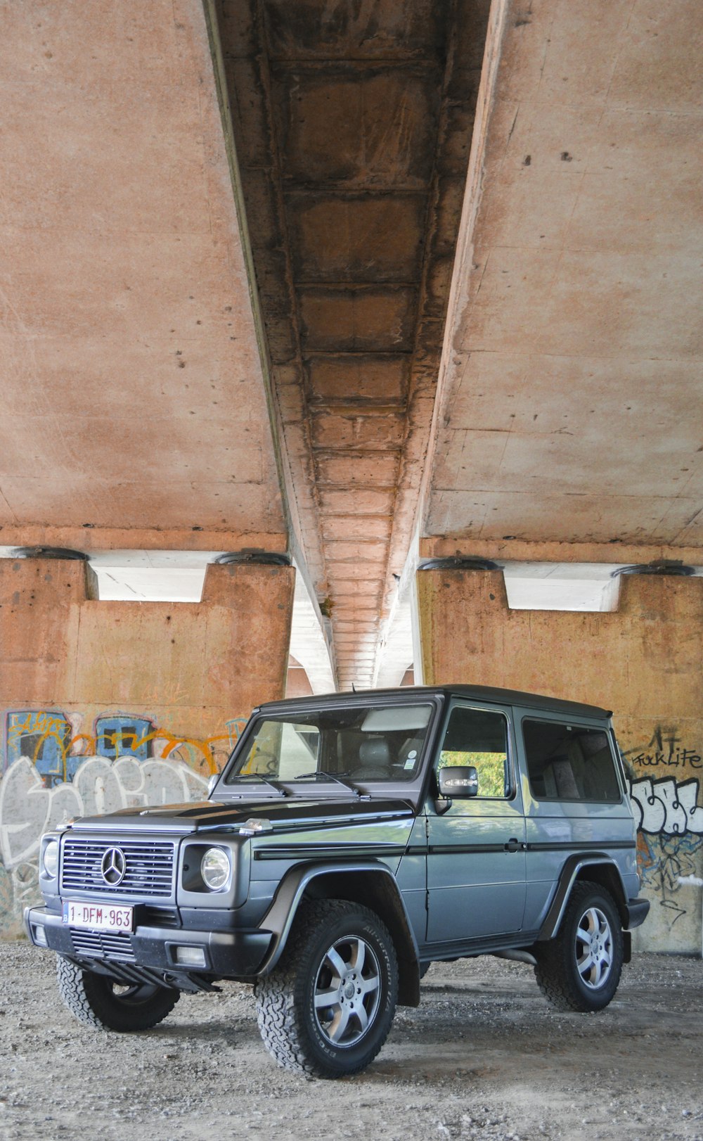 SUV Mercedes-Benz bleu et noir sous le pont pendant la journée