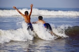 Two boys in swim gear excitedly pointing to their swimming and sports domains.