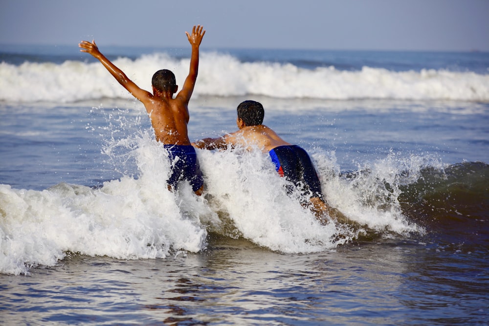 two boys playing with the waves