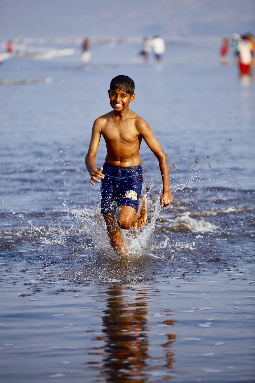 boys in blue shorts running in water