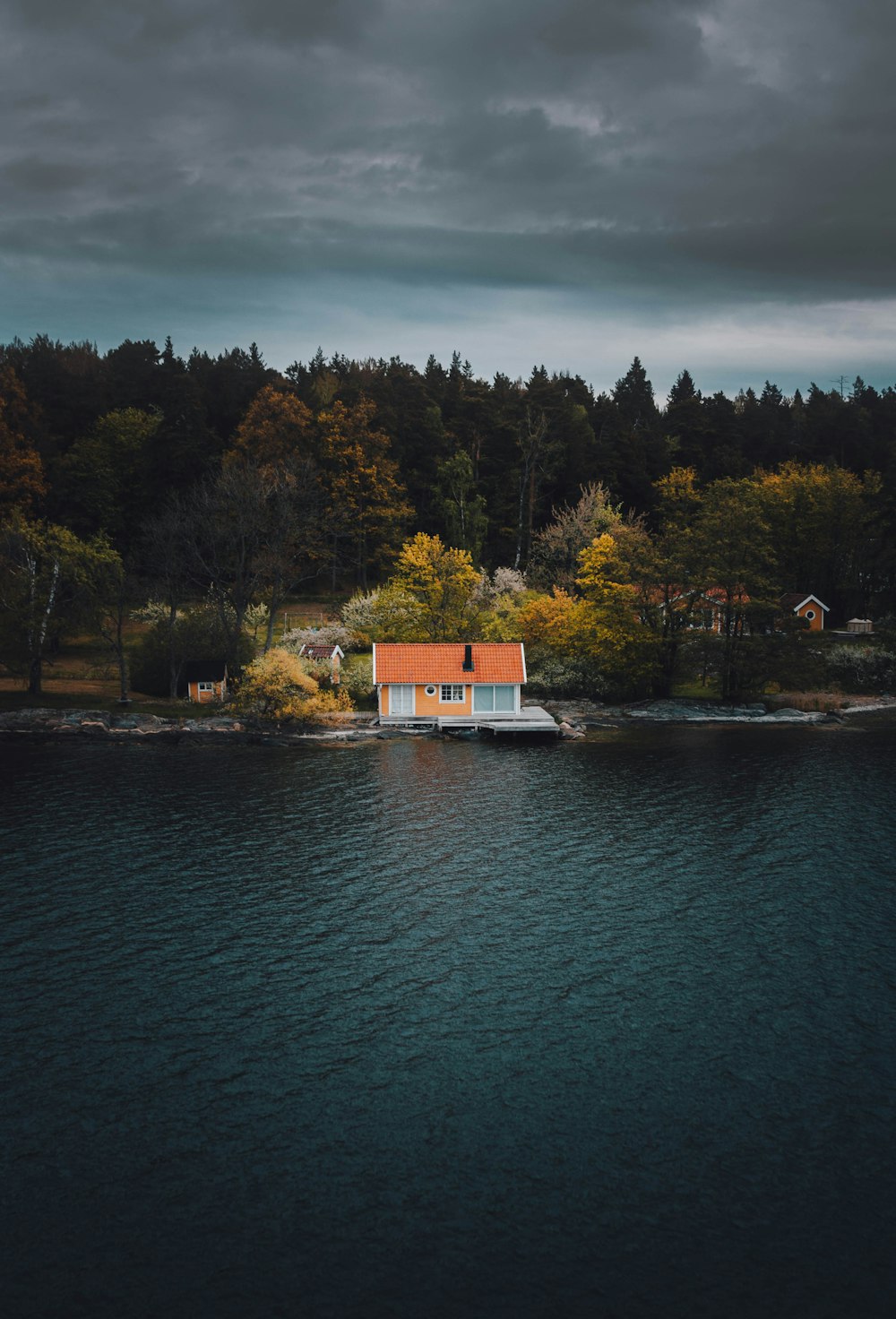 red house beside lake and forest