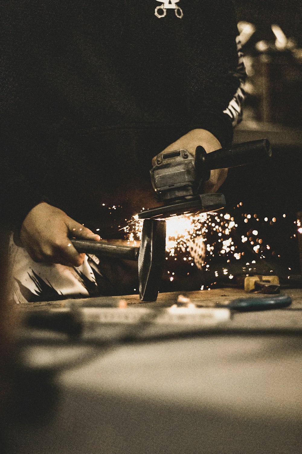 person using grinder and hammer