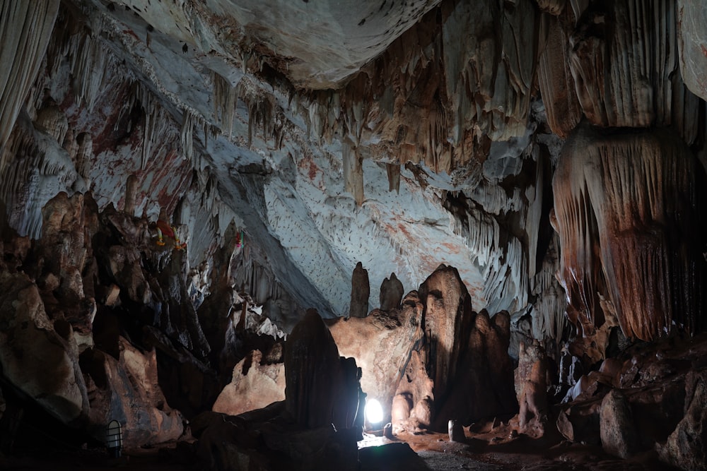 lighted lamp inside brown cave