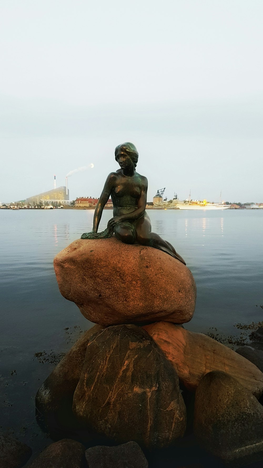 statue féminine sur rocher pendant la journée