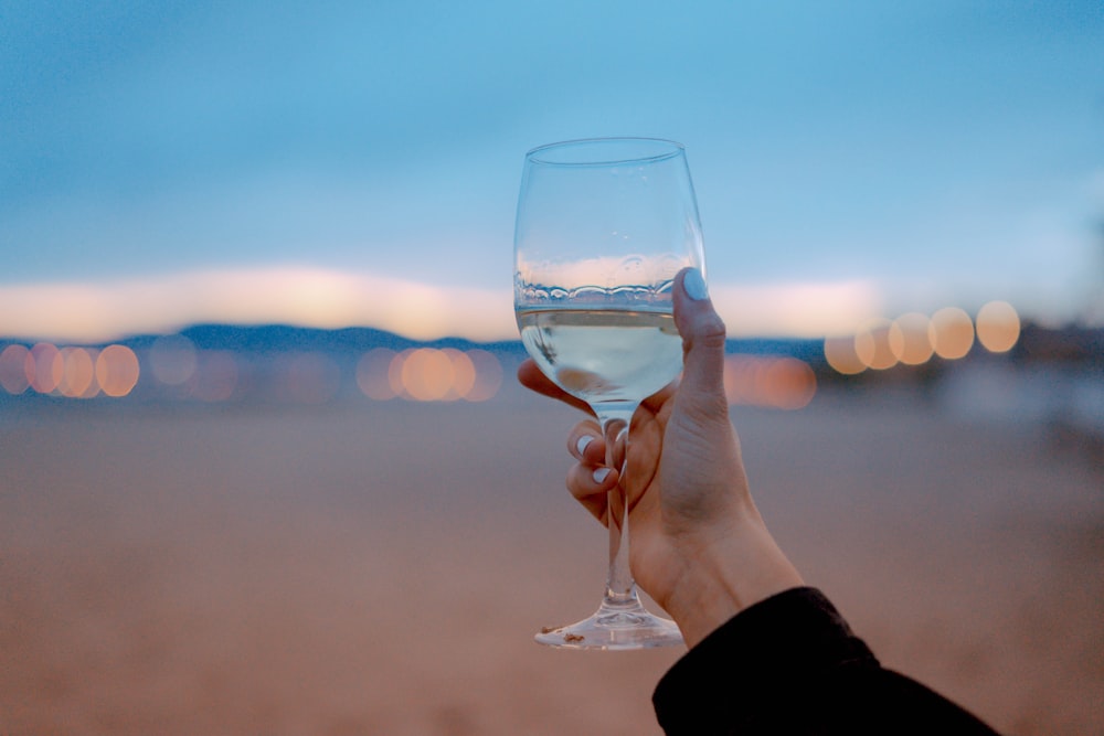 Photographie sélective de la personne tenant un verre de vin