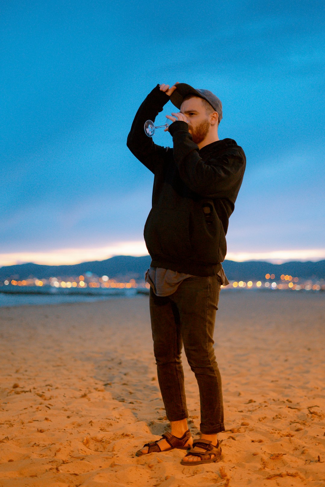 man wearing black sweater while drinking