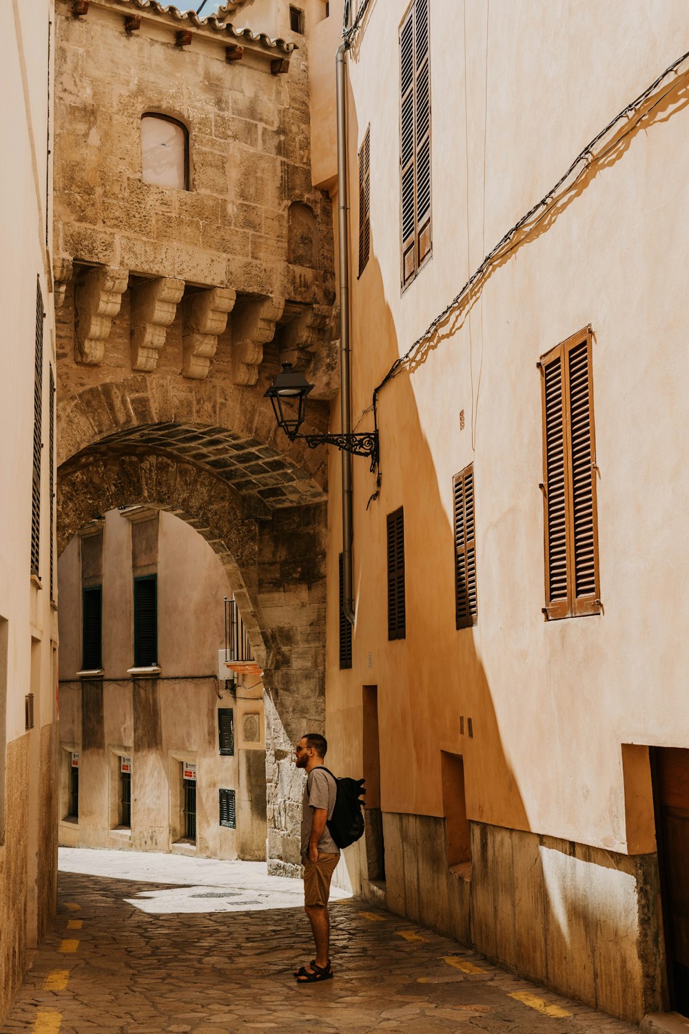 man standing near brown building