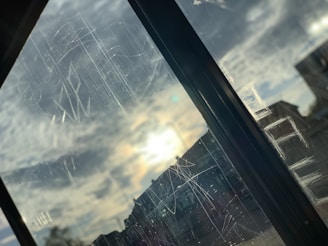Close-up of a sleek tempered glass window reflecting a desert landscape at sunset.