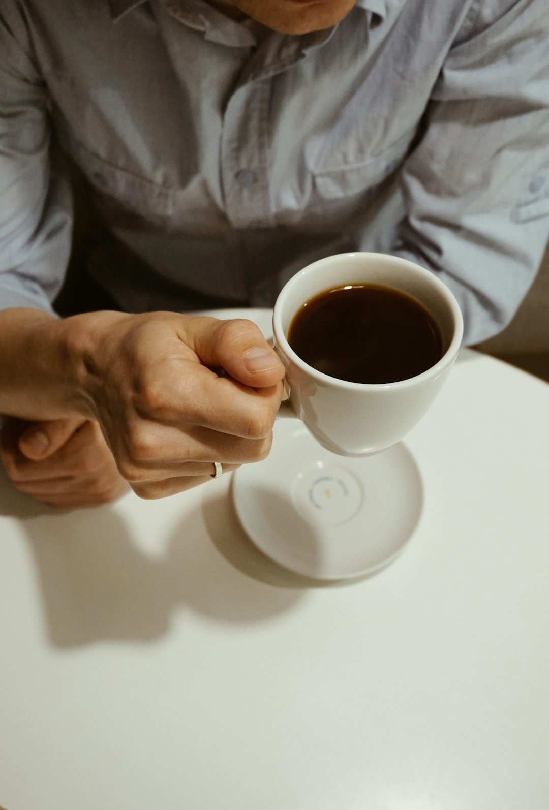 person holding white mug with coffee