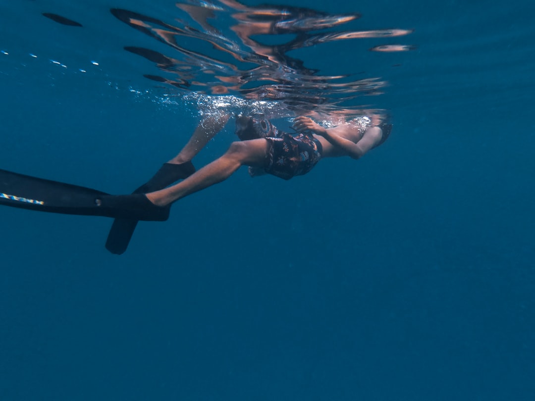 man floating on body of water