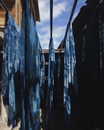 a row of blue towels hanging from a clothes line