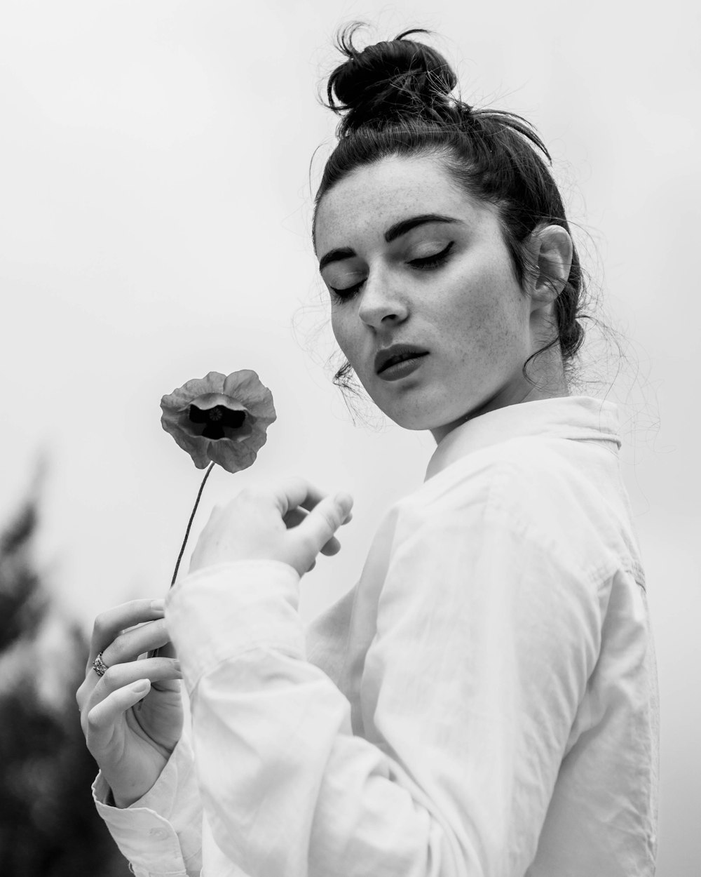 grayscale photo of woman holding flower